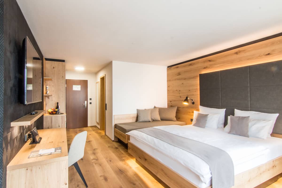 A modern bedroom with a wooden bed, a desk, and a chair.