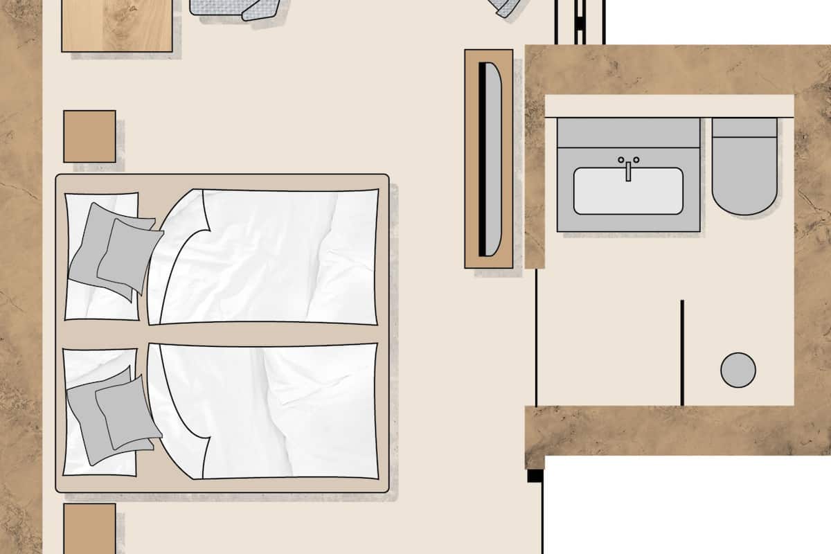 A hotel room layout with a bed, two bedside tables, a desk, a chair, a round table, a sofa, a bathroom with a sink and toilet, and a small circular rug.