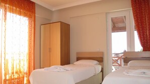 A hotel room with two beds, a wardrobe, and a view of the outdoors. - Anemon Solovilla (Fethiye)