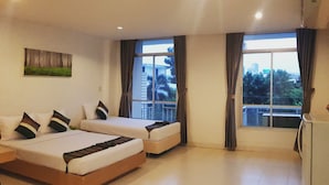 A hotel room with two beds, a large window with curtains, a small table, and a refrigerator. - Sena house Paholyothin30 (Bangkok)