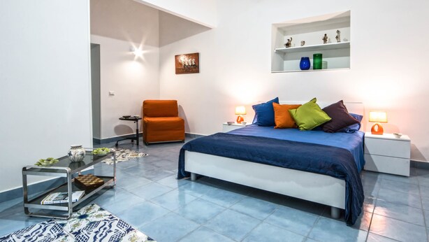 Une chambre moderne comprenant un lit, des tables de chevet, une chaise et une petite table.