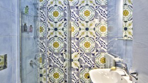 Une salle de bain avec une douche, un lavabo et un miroir.