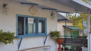 A reception area with a bench, a reception desk, and a potted plant. - Camping Aurelia Club (Rome)
