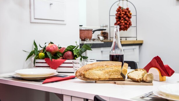 A kitchen counter with a loaf of bread, a bottle of wine, and a fruit bowl. - San Cosmo's Flat Naples Centre (Naples)