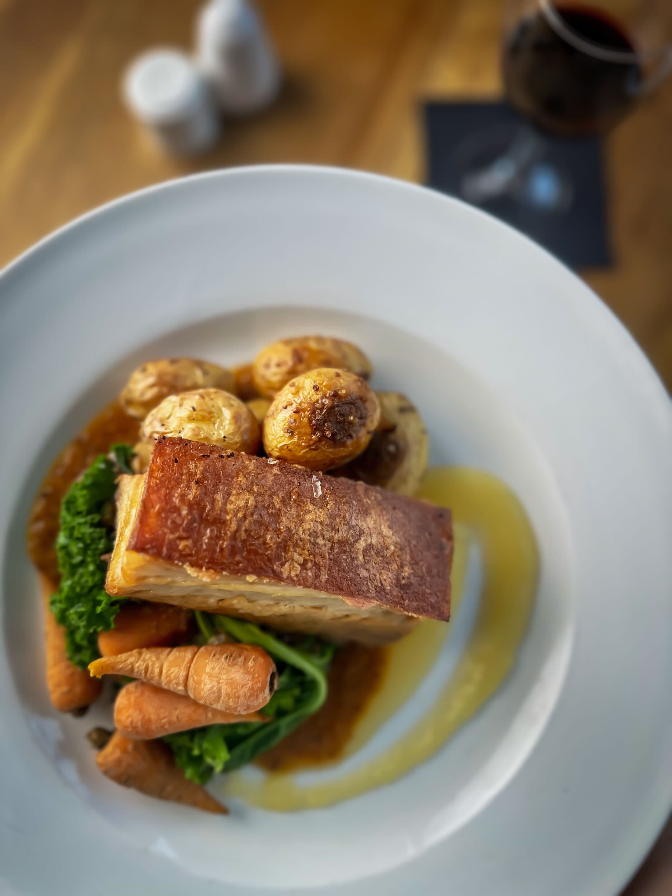 A plate of food with a piece of meat, vegetables, and a sauce.