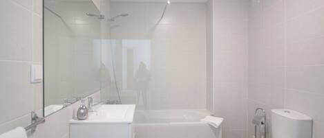 A modern bathroom with a bathtub, toilet, and sink.