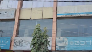 Un edificio de varios pisos con letreros que dicen 'PROFICIENCY' y 'T.P. Furniture'.