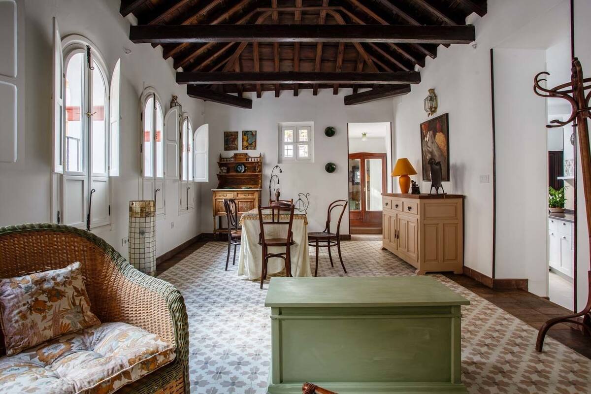 A spacious living room with a high ceiling, a dining area, and a kitchen.