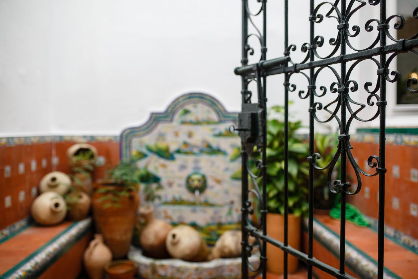Parede revestida com azulejos decorativos, incluindo um com a representação de um pássaro e uma planta.