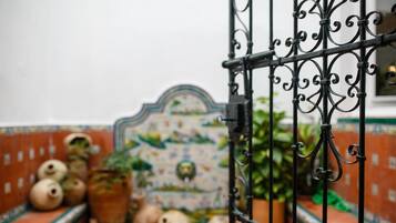 Parede revestida com azulejos decorativos, incluindo um com a representação de um pássaro e uma planta.