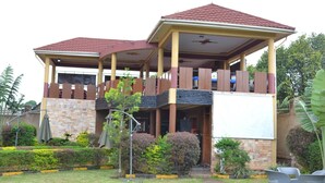 A two-story building with a covered balcony and a stone facade. - Glory Summit Hotel (Hoima)
