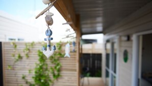 A hanging decoration with a bird, a stone, and a blue object. - Kea Cabin - beach/restaurants/supermarket all within 5 min walk. (Orewa Beach)