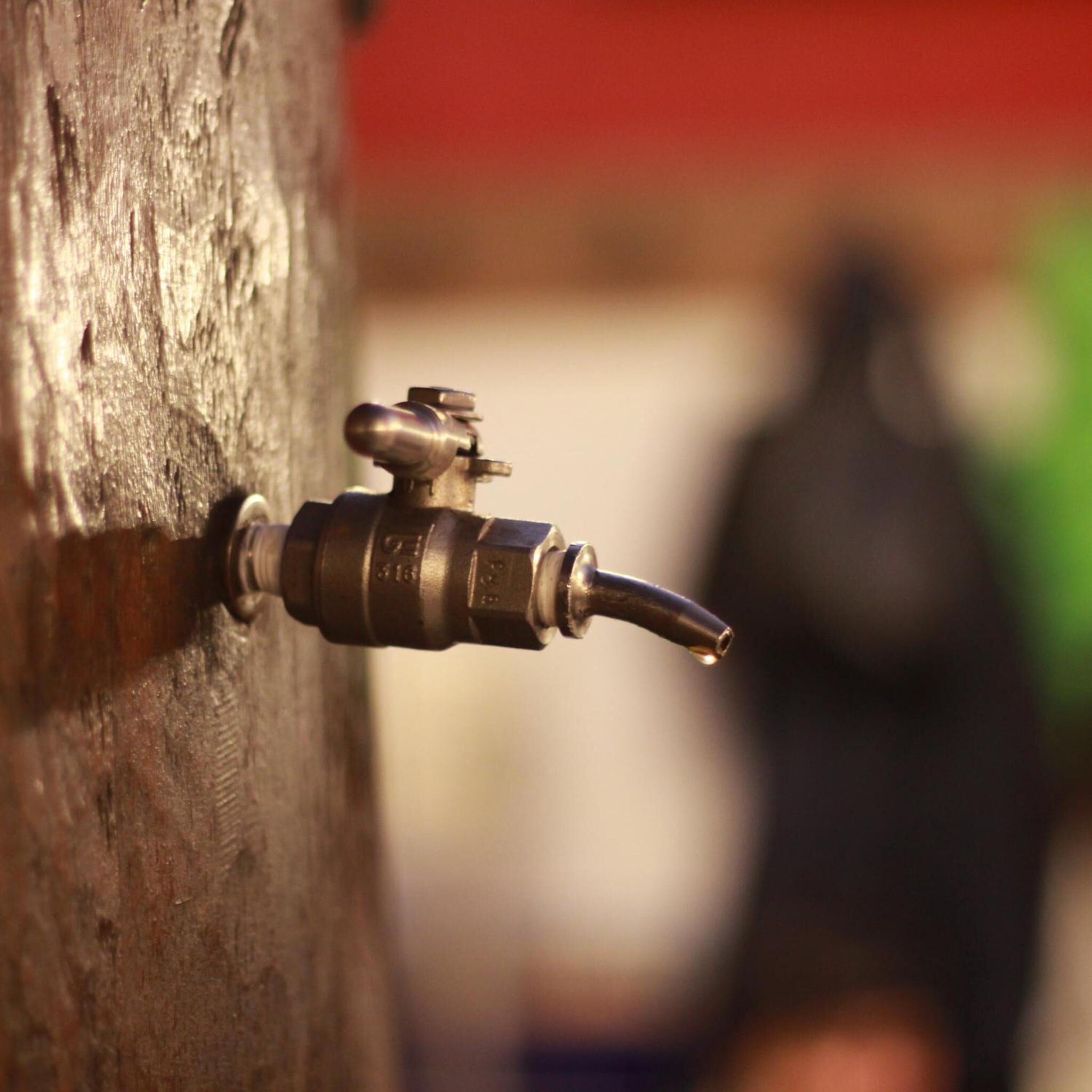 A close-up of a metal tap attached to a wooden surface.