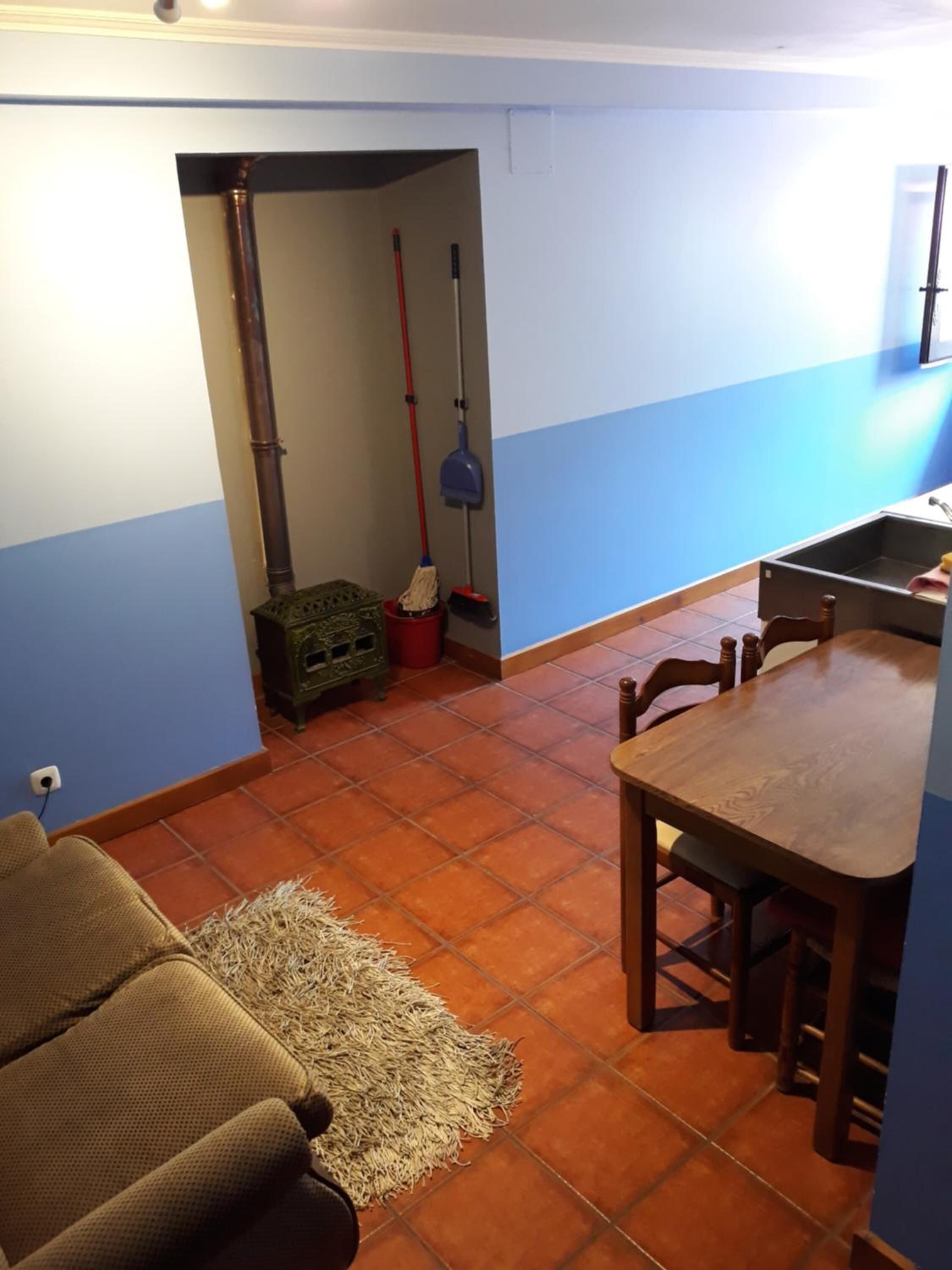 A compact living space with a dining area, a sofa, and a kitchen sink.