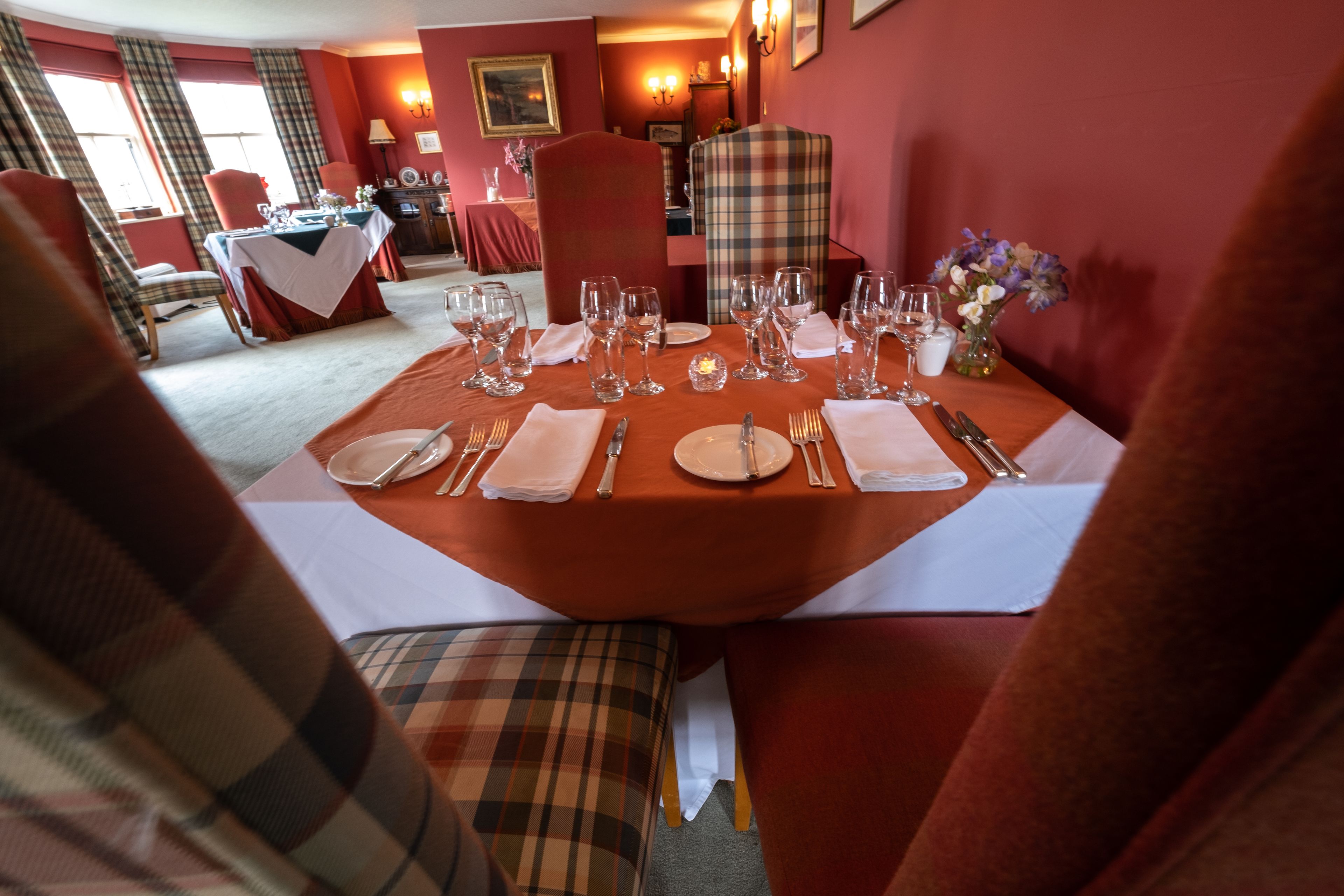 A dining area with a table set for four, including plates, cutlery, and glasses.