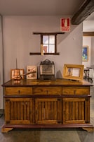 A wooden cabinet with drawers and a window above it.