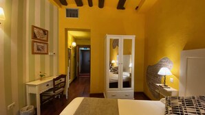Un dormitorio con cama, escritorio, armario y mesita de noche con lámpara.