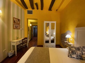 Una camera da letto con un letto, una scrivania, un armadio e un comodino con una lampada.