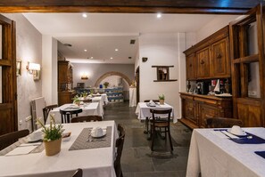 A restaurant with multiple tables, wooden cabinets, and a kitchen area in the background. - Alda Vía León (León)