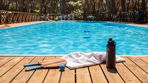 A wooden deck with a pool, a towel, and a water bottle. - Gitavillage Le Marze (Grosseto)