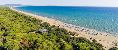 On the beach, white sand, sun loungers, beach umbrellas