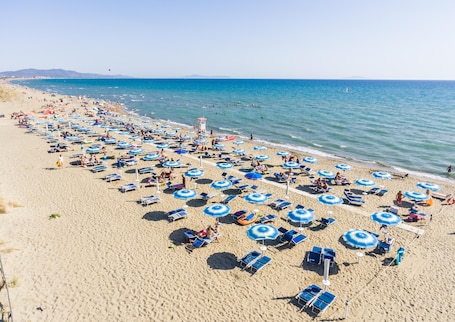 On the beach, white sand, sun loungers, beach umbrellas. Gitavillage Le Marze