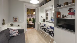 Een moderne keuken met witte kasten, een inbouwoven en een groot raam.