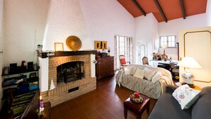 A spacious living room with a fireplace, a sofa, and a dining area.