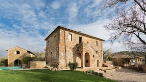 A stone building with a central tower and a smaller attached structure. - Villa Torricella (Magione)