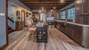 Une cuisine spacieuse dotée de meubles en bois, d’un îlot central et d’un coin repas avec des chaises.