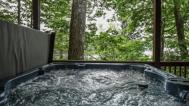 Ein Whirlpool mit Blick auf Bäume durch eine Holzterrasse.