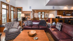 A cozy living room with a leather sofa, patterned armchair, and a wooden coffee table.