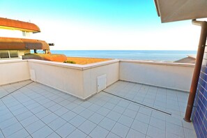 Terraço no telhado com vista para a praia e o mar.