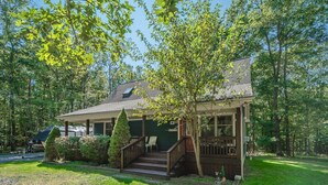 A two-story house with a porch and a covered outdoor area.
