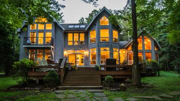 A large, two-story house with multiple windows and a wooden deck.