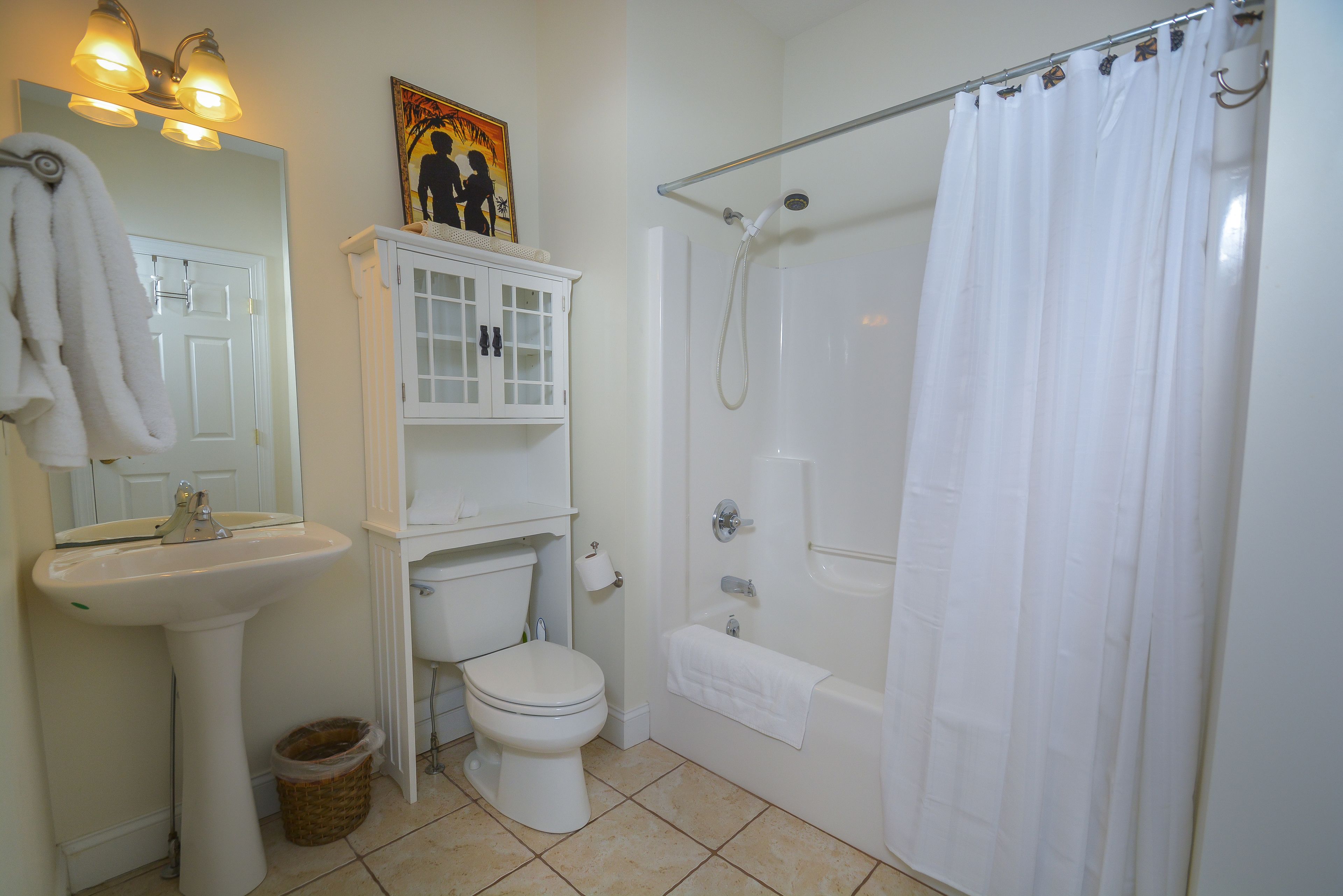 A bathroom with a sink, toilet, bathtub, and shower curtain.