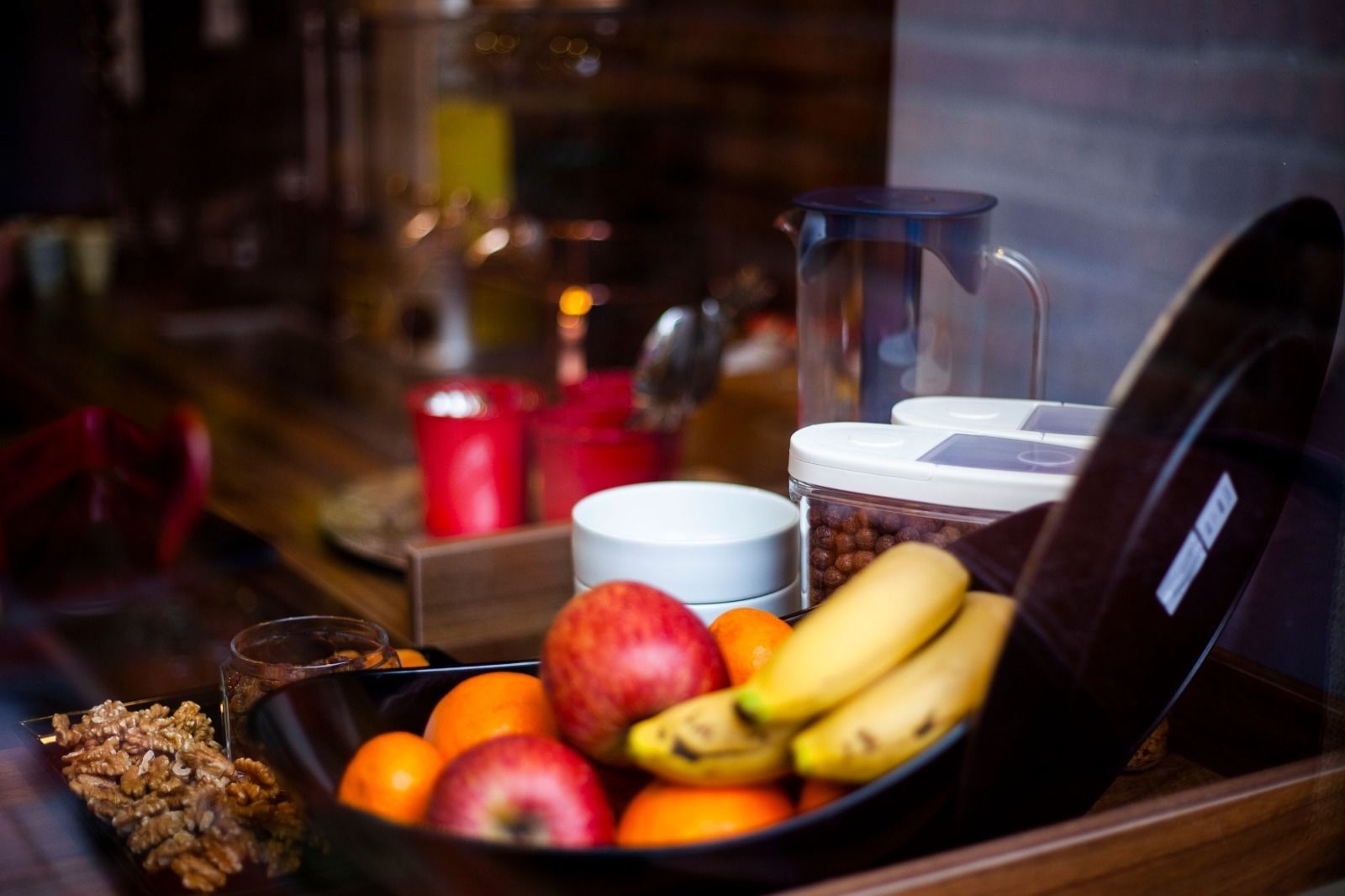 A breakfast tray with fruits, nuts, and a coffee maker.