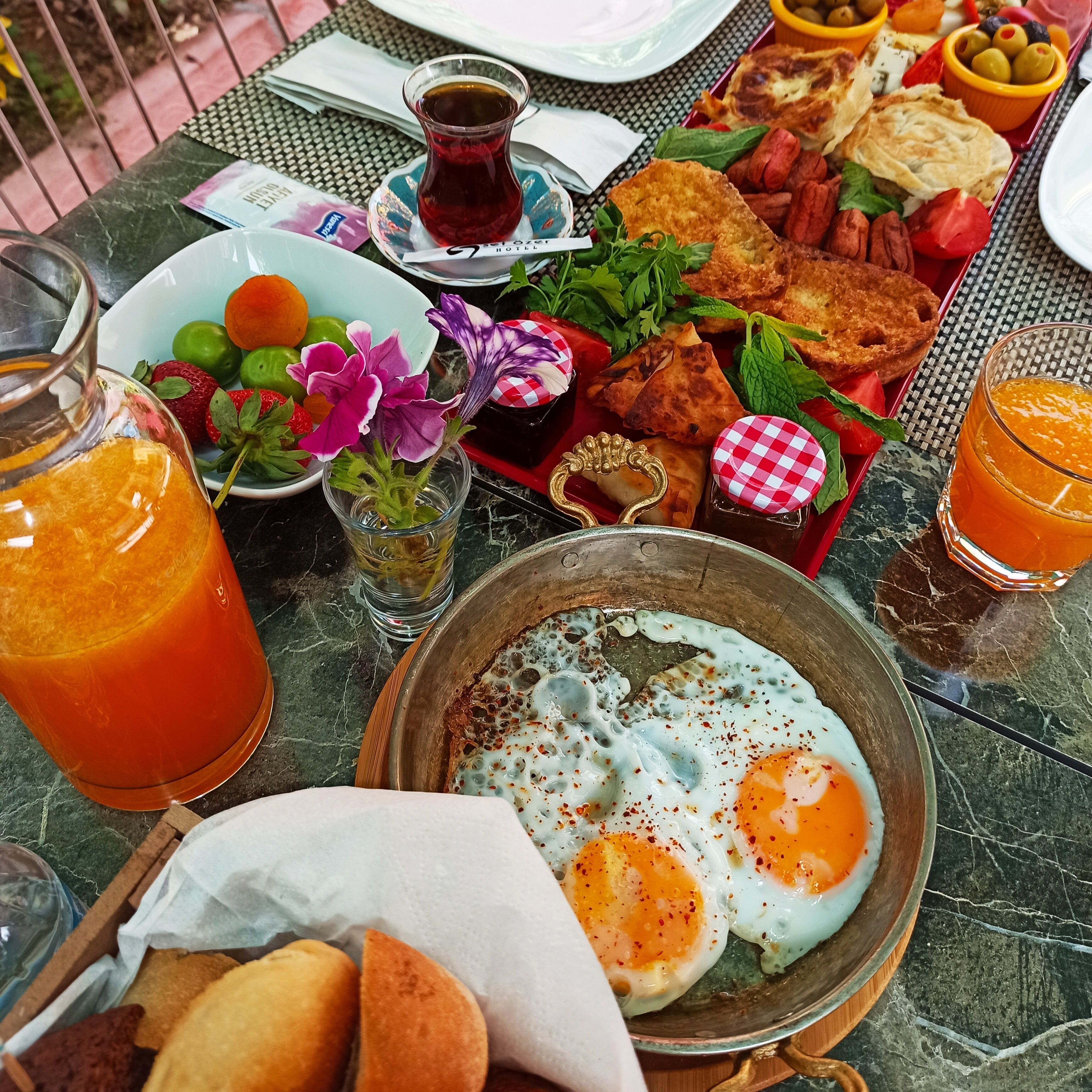 A table with a variety of breakfast items including eggs, bread, and fruit.