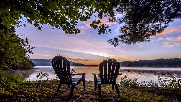 Two Adirondack chairs facing a lake with a sunset view. - Arrowhead Village 3 Bedroom Townhome #15 (Oakland)