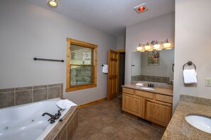 A bathroom with a bathtub, vanity with a sink, wooden cabinets, and a window with blinds.
