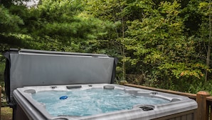 A hot tub with a wooden deck and a sign indicating emergency use.