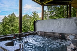 A hot tub with a view of a forested area. - Vista Bonita 5 Bedroom House (McHenry)