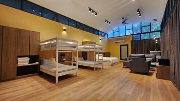 A modern hotel room with bunk beds, a sofa, and a desk.