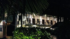 Un edificio con balcón y un jardín bien cuidado.