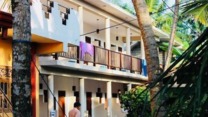 Un edificio de dos pisos con un balcón y una escalera.