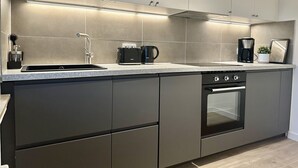 Una cocina moderna con horno empotrado, cafetera y tostadora.