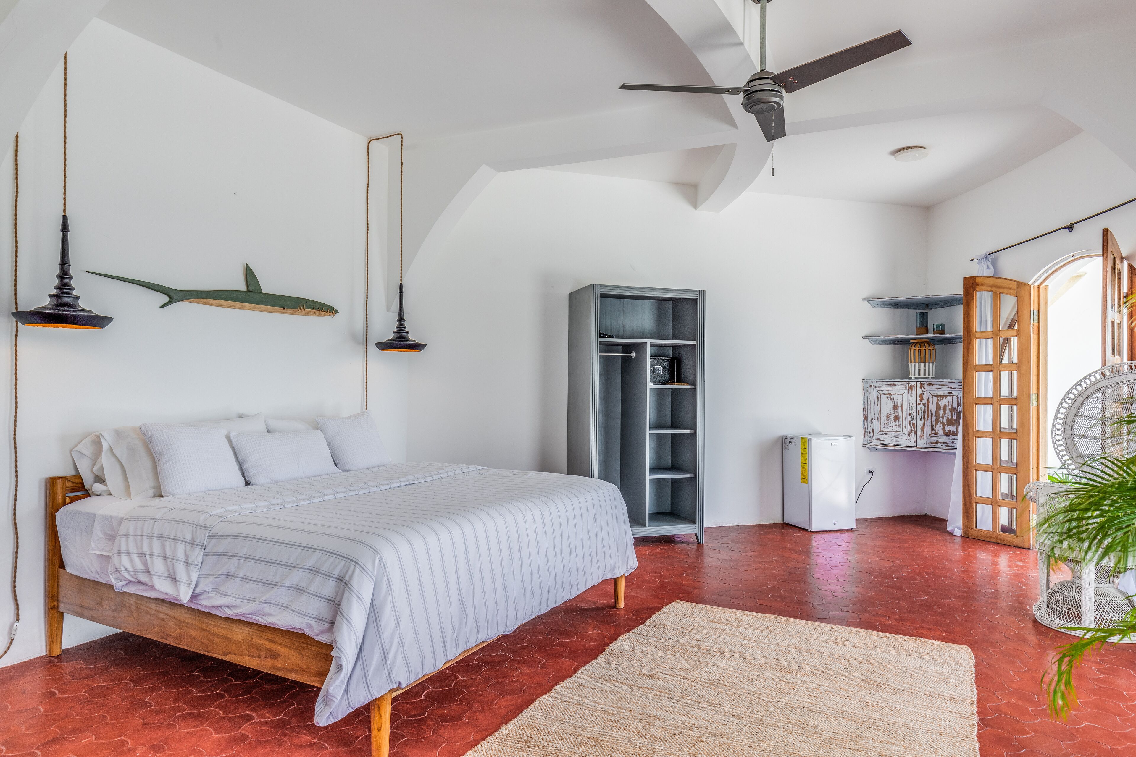 A bedroom with a bed, a ceiling fan, a wardrobe, and a radiator.