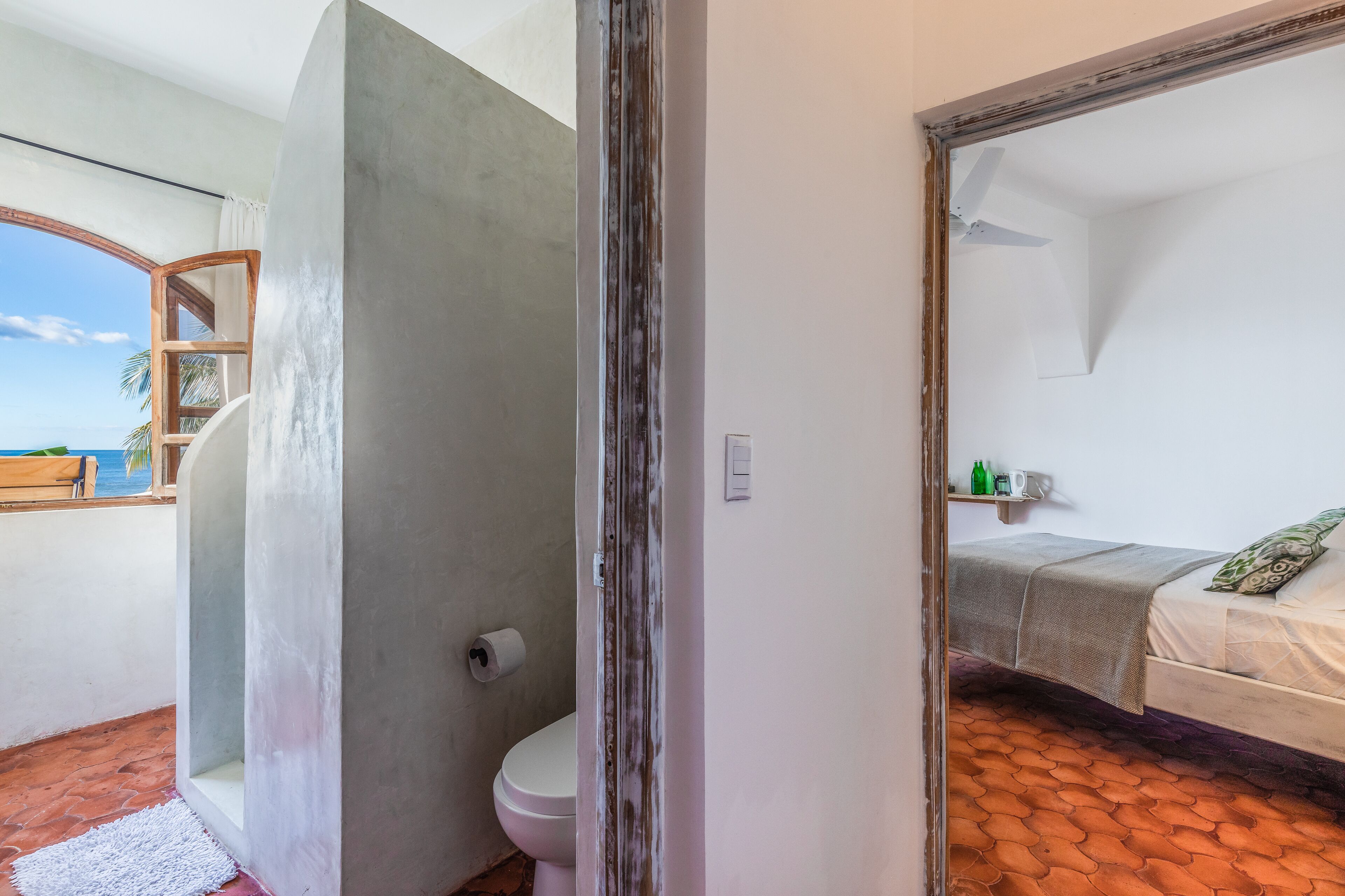 A bathroom with a toilet, a shower, and a large mirror.