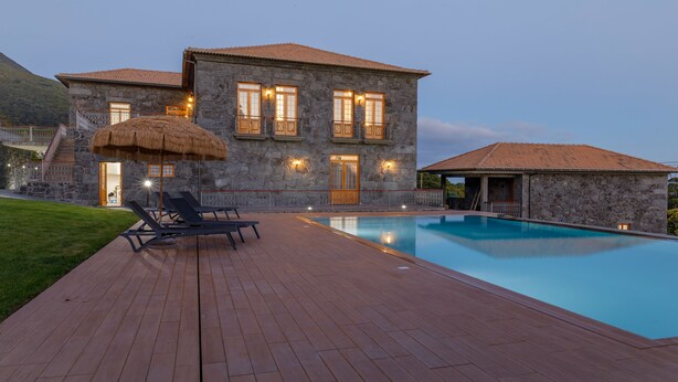 A stone building with a swimming pool, a covered seating area, and a staircase leading to the entrance. - Quinta da Magnólia (Velas)