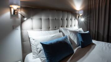 A hotel room with a tufted headboard, white bedding, and two wall-mounted light fixtures.